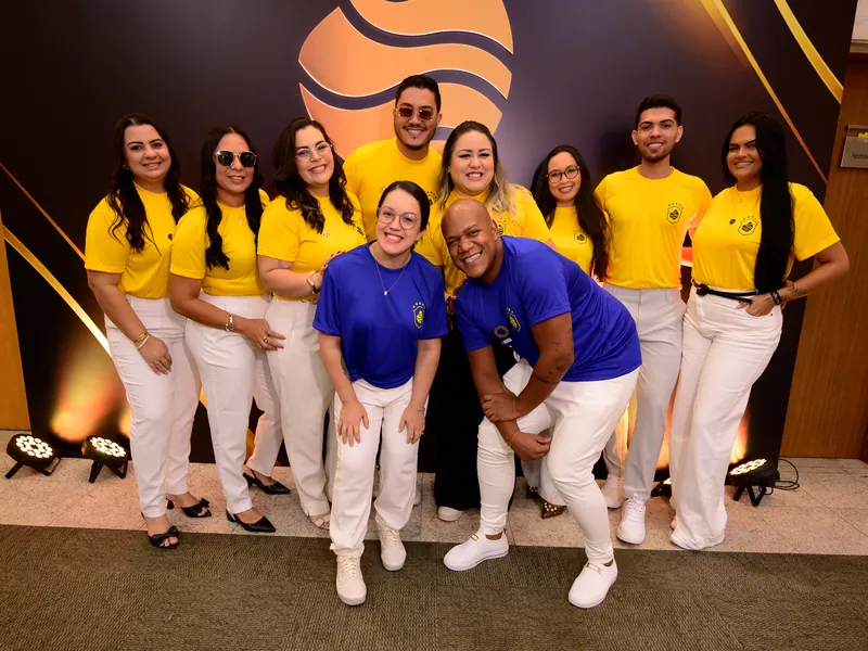 Equipe e participantes em frente ao painel Mag Color